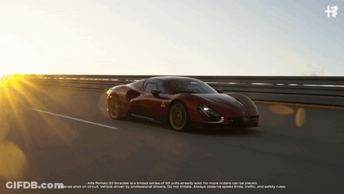 A Red Alfa Romeo Car Is Driving Down A Highway At Sunset GIF