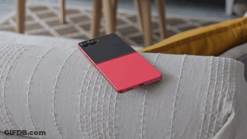 A Red And Black Cell Phone Is Laying On A White Couch GIF