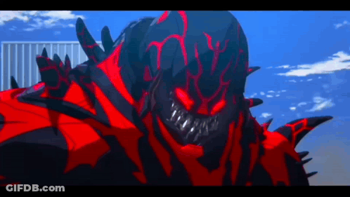 A Red And Black Monster With Sharp Teeth Is Standing In Front Of A Building GIF