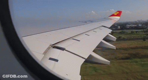 A Red And White Airplane Wing With A Yellow Star On The Tail GIF