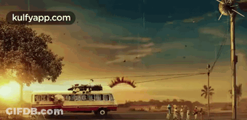 A Red And White Bus With A Christmas Tree On Top Of It Is Driving Down A Street . GIF