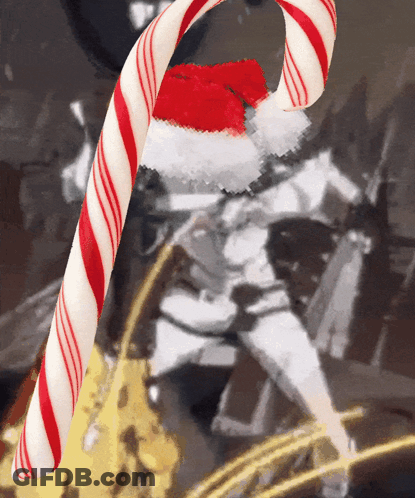 A Red And White Candy Cane With A Santa Hat On GIF
