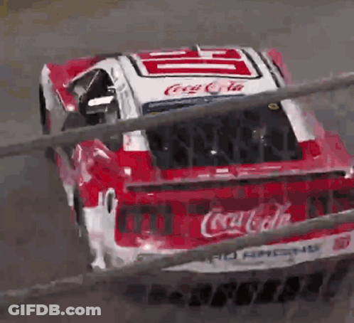 A Red And White Coca Cola Race Car Is Going Down A Track GIF