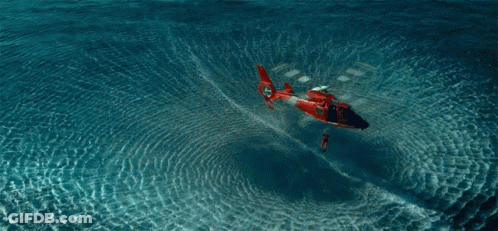 A Red And White Helicopter Is Floating In The Ocean GIF