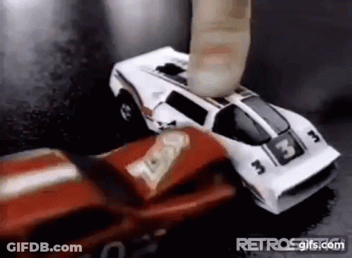 A Red And White Toy Car Is Being Smashed By A Finger . GIF