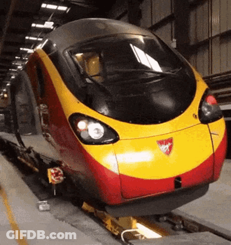 A Red And Yellow Train With A Shield On The Front GIF