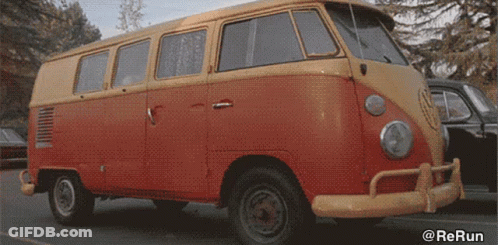 A Red And Yellow Van Is Parked In A Parking Lot With The Watermark @Rerun GIF