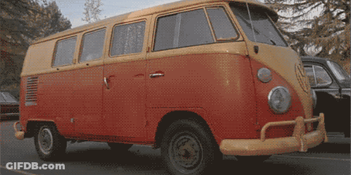 A Red And Yellow Van Is Parked On A Street GIF