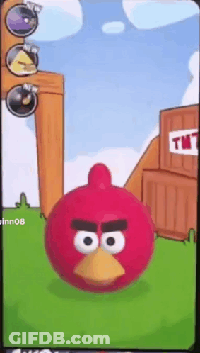 A Red Angry Bird Is Standing In Front Of A Tnt Building GIF