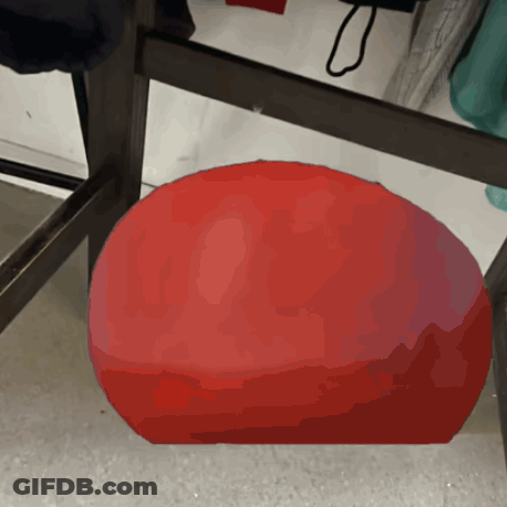 A Red Ball Is Sitting On A Table In A Store GIF