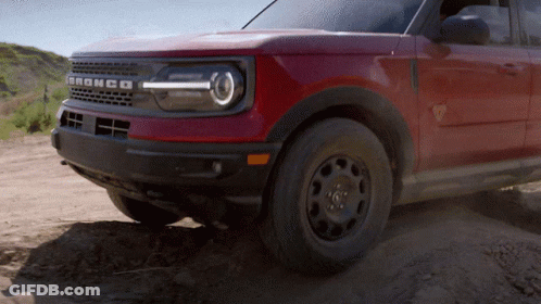 A Red Bronco Is Driving Through The Dirt On A Dirt Road GIF
