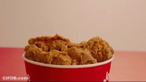 A Red Bucket Filled With Fried Chicken Has The Word Jc On It GIF