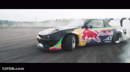 A Red Bull Car Is Driving On A Track GIF