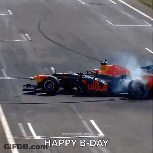 A Red Bull Race Car Is Driving Down A Track With Smoke Coming Out Of The Tire GIF