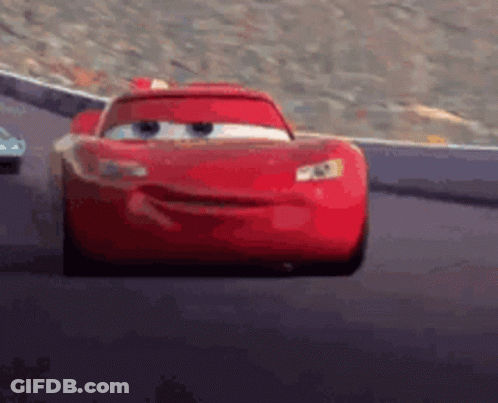 A Red Car From The Movie Cars Is Driving Down A Track . GIF