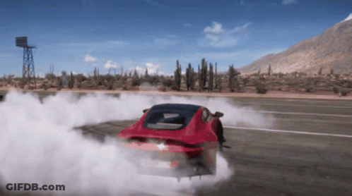 A Red Car Is Drifting On A Desert Road With Mountains In The Background GIF