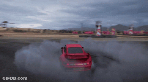 A Red Car Is Drifting On A Track And Smoke Is Coming Out Of It GIF