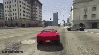 A Red Car Is Driving Down A City Street With Buildings In The Background . GIF
