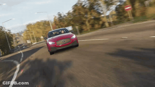 A Red Car Is Driving Down A Road With A No Entry Sign In The Background GIF