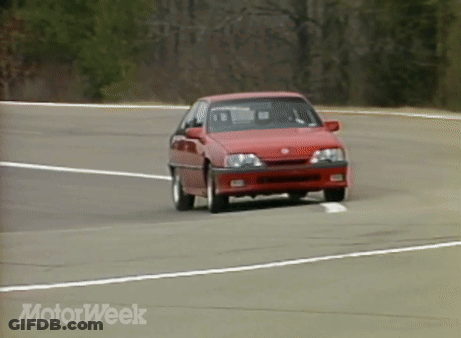 A Red Car Is Driving Down A Road With Motorweek Written In The Corner GIF