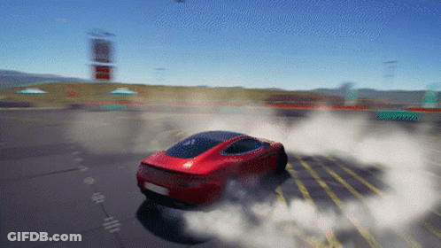 A Red Car Is Driving Down A Road With Smoke Coming Out Of The Tire GIF
