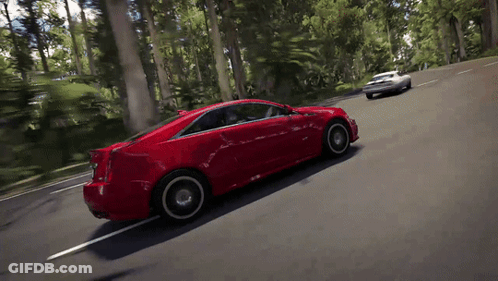 A Red Car Is Driving Down A Road With Trees On The Side GIF