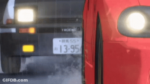 A Red Car Is Driving Next To A Black Car On A Road . GIF