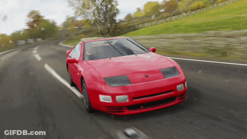 A Red Car Is Driving On A Curvy Road GIF