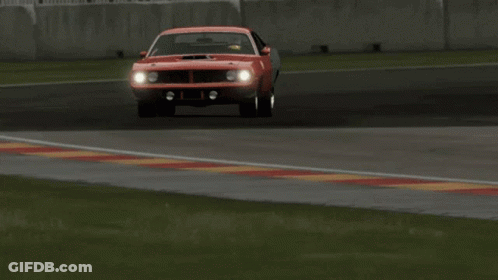 A Red Car Is Driving On A Race Track With A Chevrolet Sign In The Background GIF