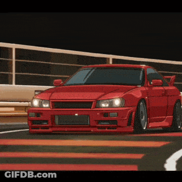 A Red Car Is Driving On A Road With A Fence In The Background GIF