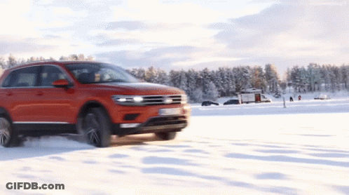 A Red Car Is Driving On A Snowy Road With A License Plate That Says ' Tdi ' On It GIF