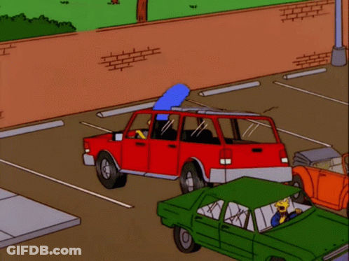 A Red Car Is Parked In A Parking Lot With A Green Car Next To It GIF