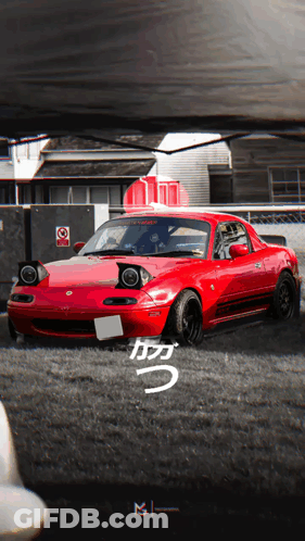 A Red Car Is Parked In A Parking Lot With A Sign That Says No Smoking GIF