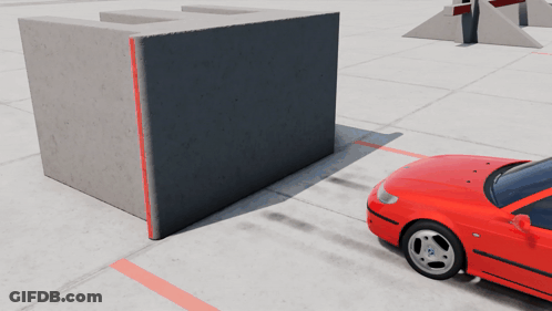 A Red Car Is Parked In Front Of A Concrete Wall GIF