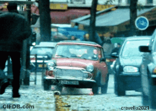 A Red Car With A License Plate That Starts With The Letter C Is Driving Down A Busy Street GIF