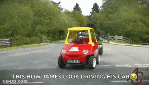 A Red Car With A Yellow Top Is Driving Down A Road With The Caption This How James Look Driving His Car GIF