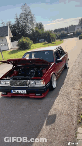 A Red Car With The License Plate Hln 473 Is Parked On The Street GIF