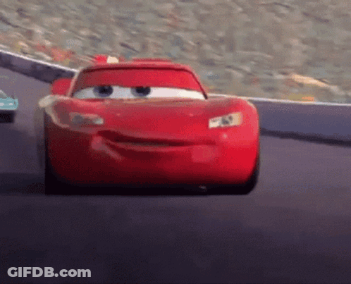 A Red Cartoon Car Is Driving Down A Road GIF