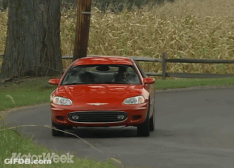 A Red Chrysler Car Driving Down A Road GIF