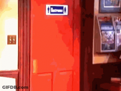 A Red Door With A Blue Sign On It That Says Restrooms GIF