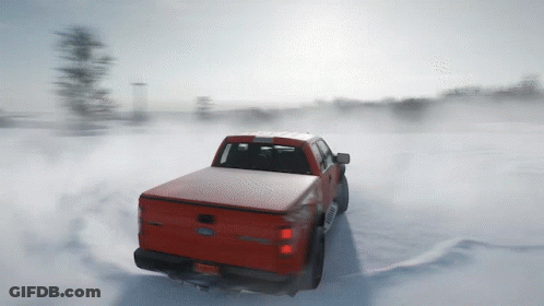 A Red Ford Truck Driving Through The Snow GIF
