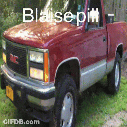 A Red Gmc Truck Is Parked On The Grass GIF
