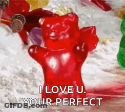 A Red Gummy Bear Is Sitting On Top Of A Pile Of Gummy Bears . GIF