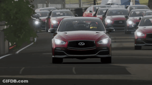 A Red Infiniti Car Driving Down A Road GIF