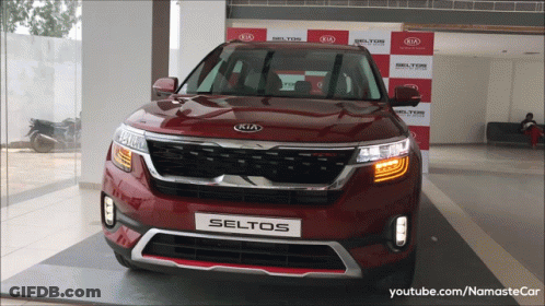 A Red Kia Seltos Is On Display At A Kia Dealership GIF
