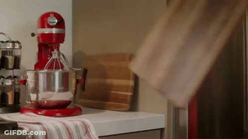 A Red Kitchenaid Mixer Is On A Kitchen Counter GIF