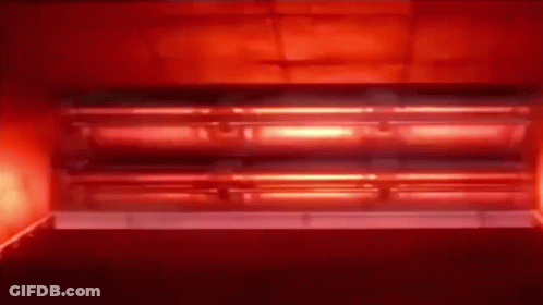 A Red Light Is Coming Out Of A Red Oven . GIF