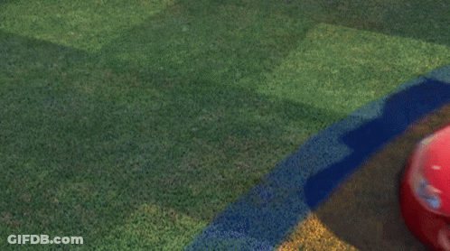 A Red Lightning Mcqueen From Cars Is Driving On A Grassy Field GIF