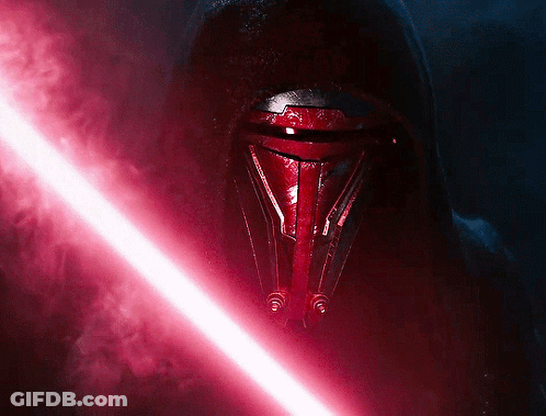 A Red Lightsaber Is Being Held By A Person In A Dark Room GIF
