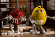 A Red M & M And A Yellow M & M Are Standing Next To Each Other In A Gym GIF